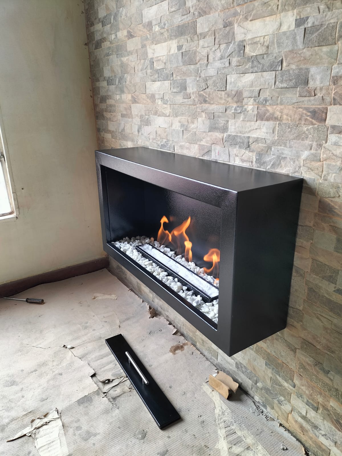 Chimenea empotrada en muro de piedra natural apilada